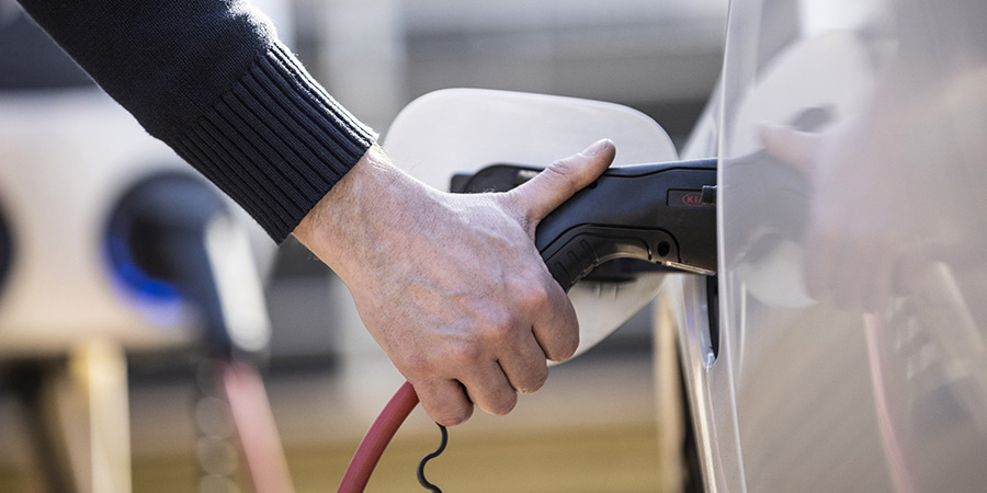 lähikuva jossa kaapeli on kiinnitetty sähköautoon