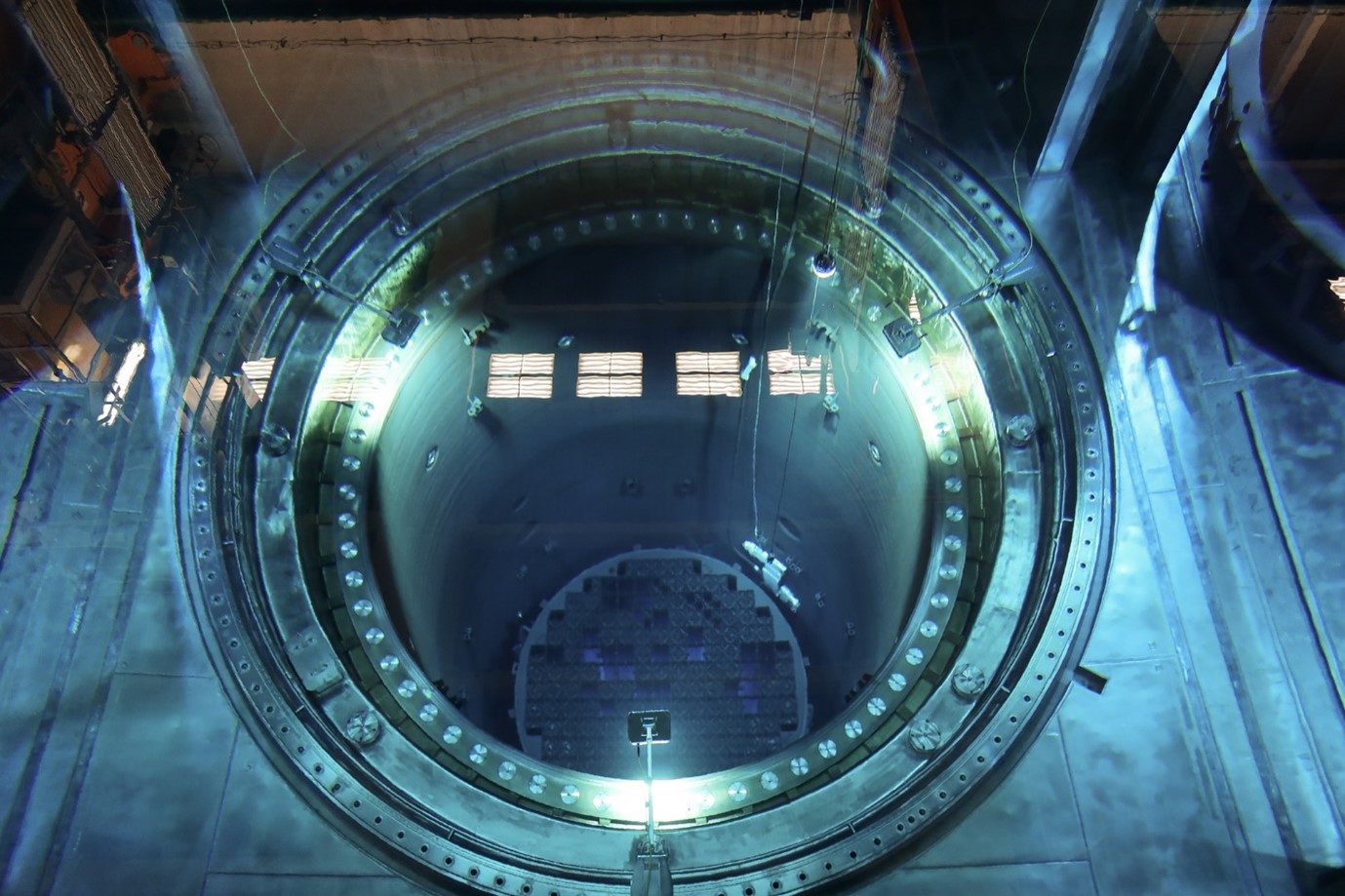 Jonkin ydinvoimalan pyöreänmallinen rakennelma sinisellä valaistuksella, tämän sivun editori ei tiedä sen tarkemmin koska ei ole ydinfyysikko