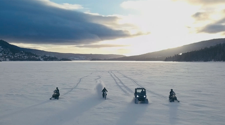 Talvinen lumen peittämä jääkenttä jonka läpi ajavat vierekkäin neljä erilaista sähkömoottorikelkkaa