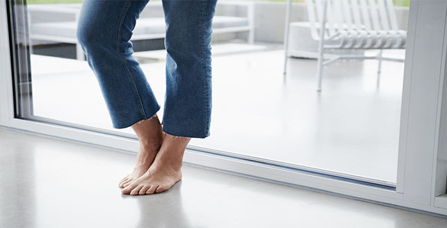 Kuva lattianrajasta jossa näkyy henkilön jalat