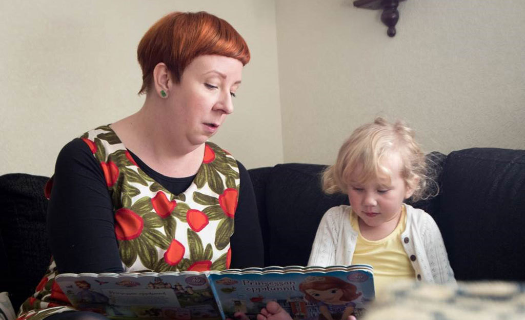 Jenni Kokander ja pieni lapsi lukevat yhdessä