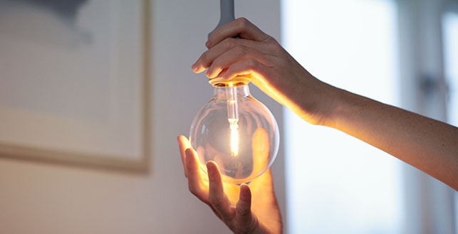 hohtavaa lamppua asettelevat kädet