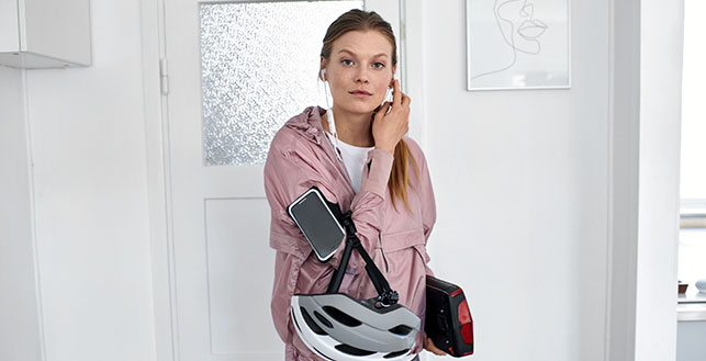 Nainen pyöräilykypärän kanssa katsoo kohti kameraa