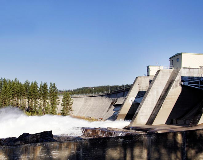 Näkymä vesivoimalasta, kuvassa näkyy voimalan patoa ja jylläävää vettä
