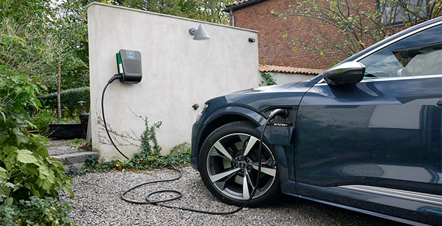 Sähköauto kiinni laturissa pihalla