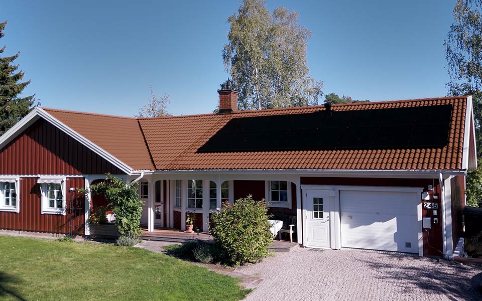 Punainen talo, jonka katolla on aurinkopaneeleja.