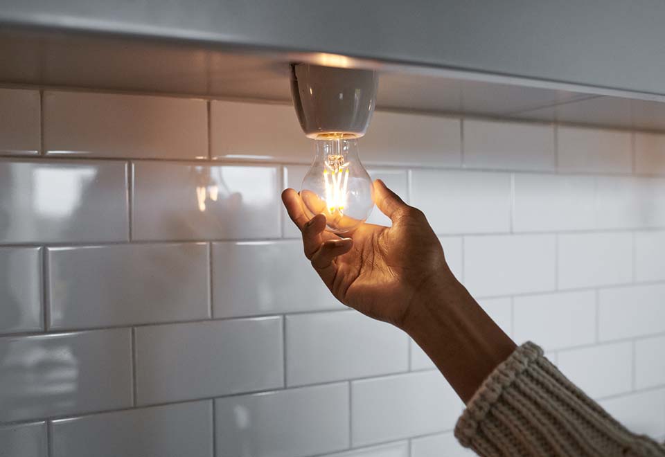 Nainen asentaa lamppua