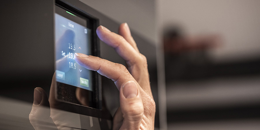 Lähikuva lämmityslaitteen kontrollipaneelista jota ollaan säätämässä