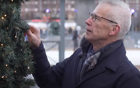 Kuva sivultapäin miehestä joka katselee joulukuusta