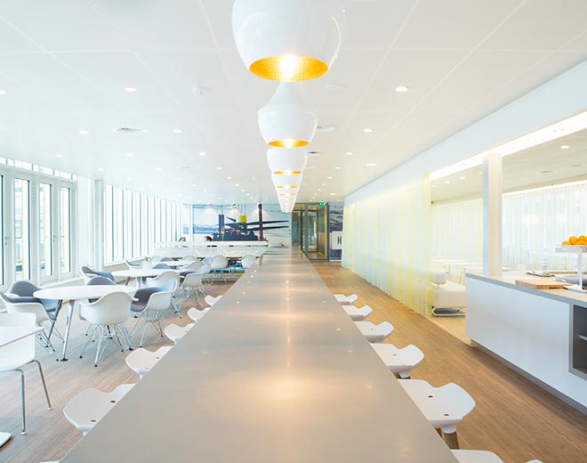 Yritysrakennuksen valoisa ja valkea aula/kokoontumistila