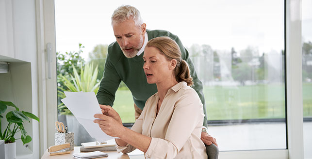 Nainen ja mies katsomassa läpi papereita yhdessä