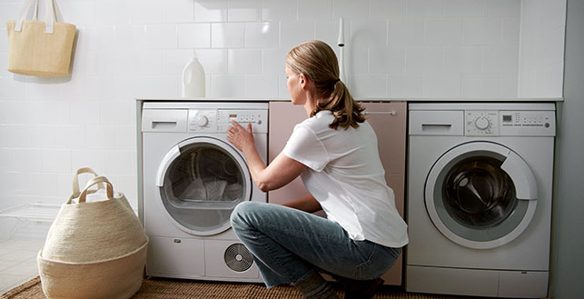 Nainen säätämässä pesukonetta