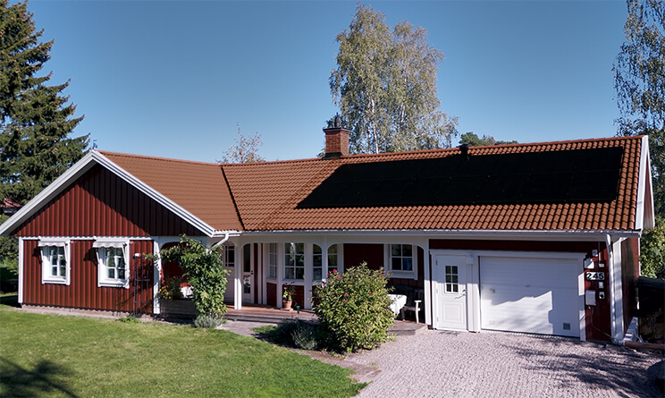 Punainen talo, jonka katolla on aurinkopaneelit.