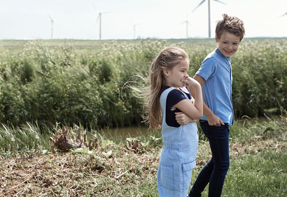 Kaksi lasta kävelee pellon laidalla