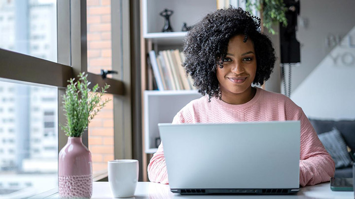 Hymyilevä nainen käyttää tietokonetta?