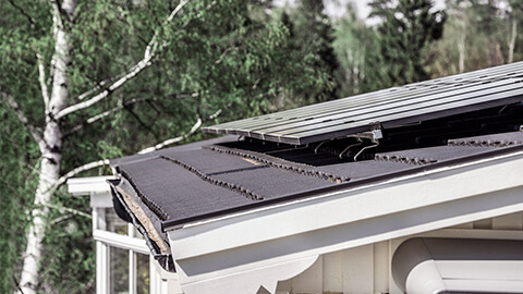 Lähikuva aurinkopaneeleista talon katolla.
