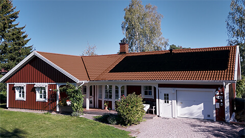 Punainen talo, jonka katolla aurinkopaneelit.
