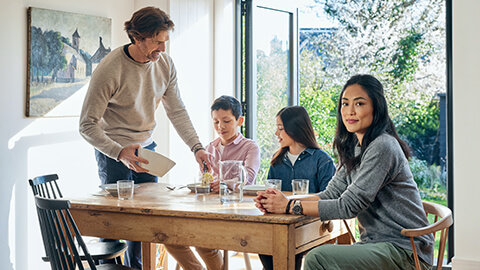 Familj som sitter vid köksbord.