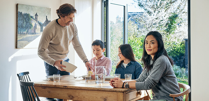 Perhe istumassa pöydän ääressä.