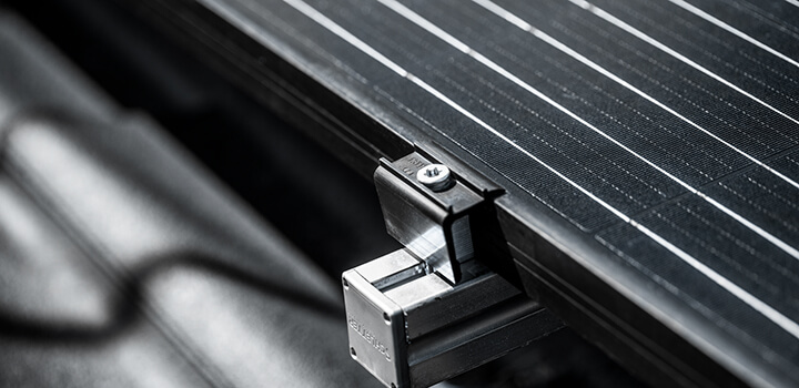 Lähikuva aurinkopaneelista ja kiinnikkeestä.