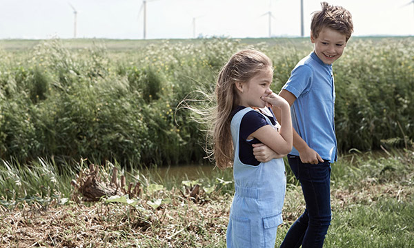 Kaksi lasta kävelee pellon laidalla