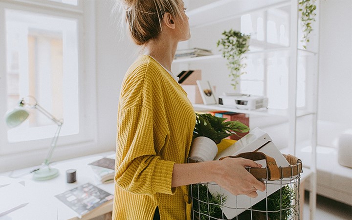 nainen kantamassa tavaroita korissa
