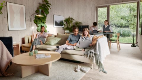 Perhe tekemässä läksyjä olohuoneessa