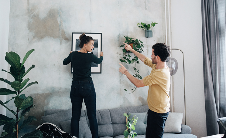 Pariskunta ripustaa taulua