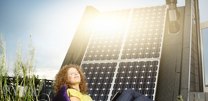 Nainen aurinkopaneelien edessä