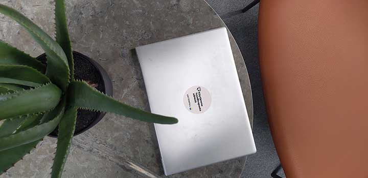 Yläkuva läppärin kannesta johon on liimattu pyöreä energiamerkki tarra