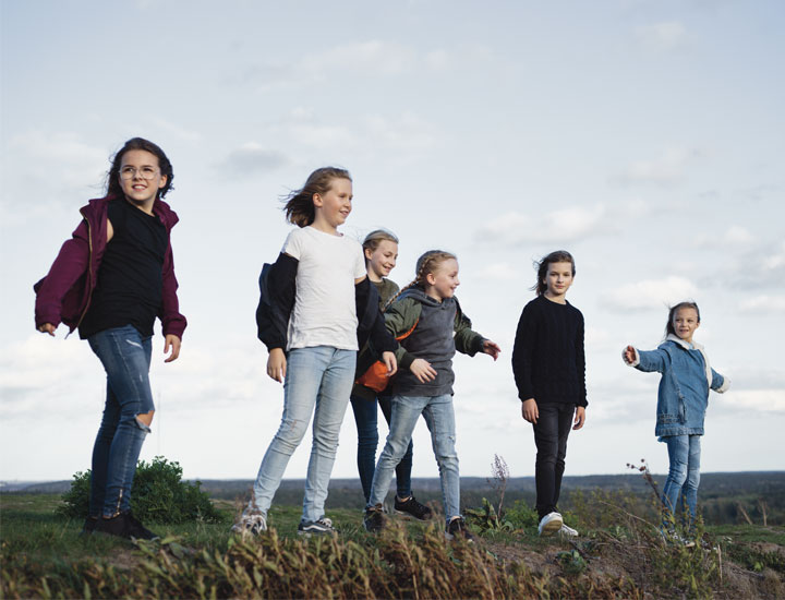 Kuusi lasta yhdessä tuulisella peltoaukealla