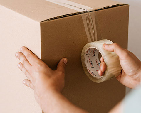 Kuva: pahvilaatikon sulkeminen teipillä